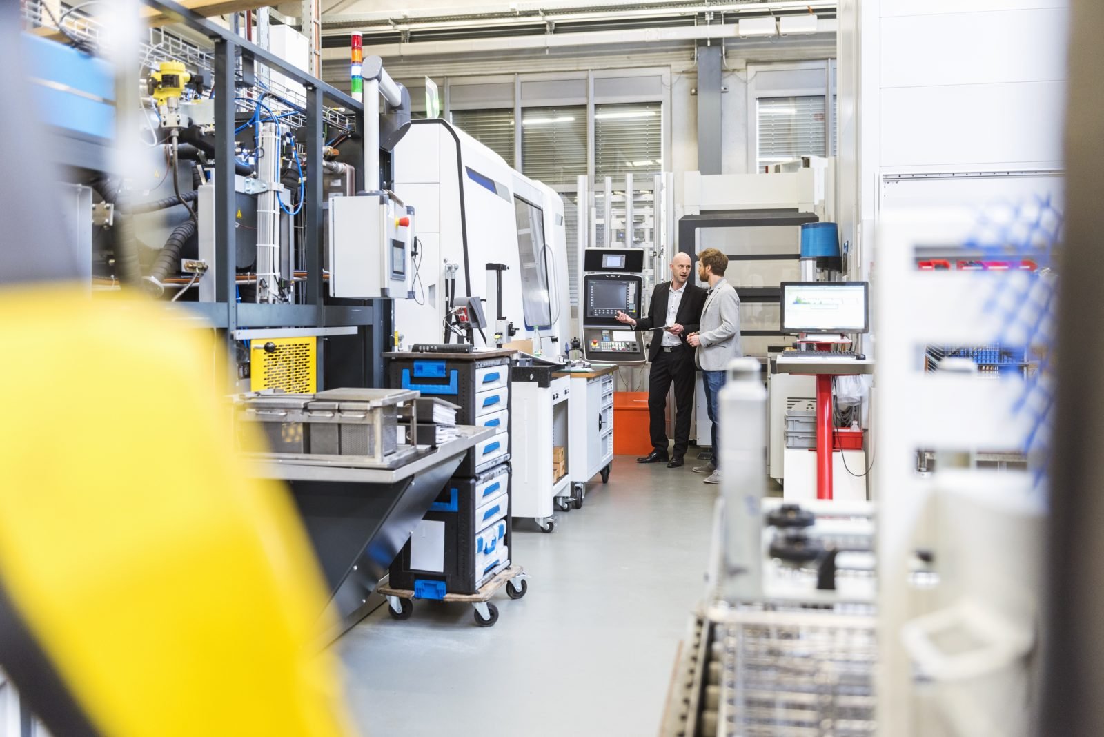 KI-Beratung für den Mittelstand: Berater und Unternehmer besprechen Digitalisierung an der Maschine