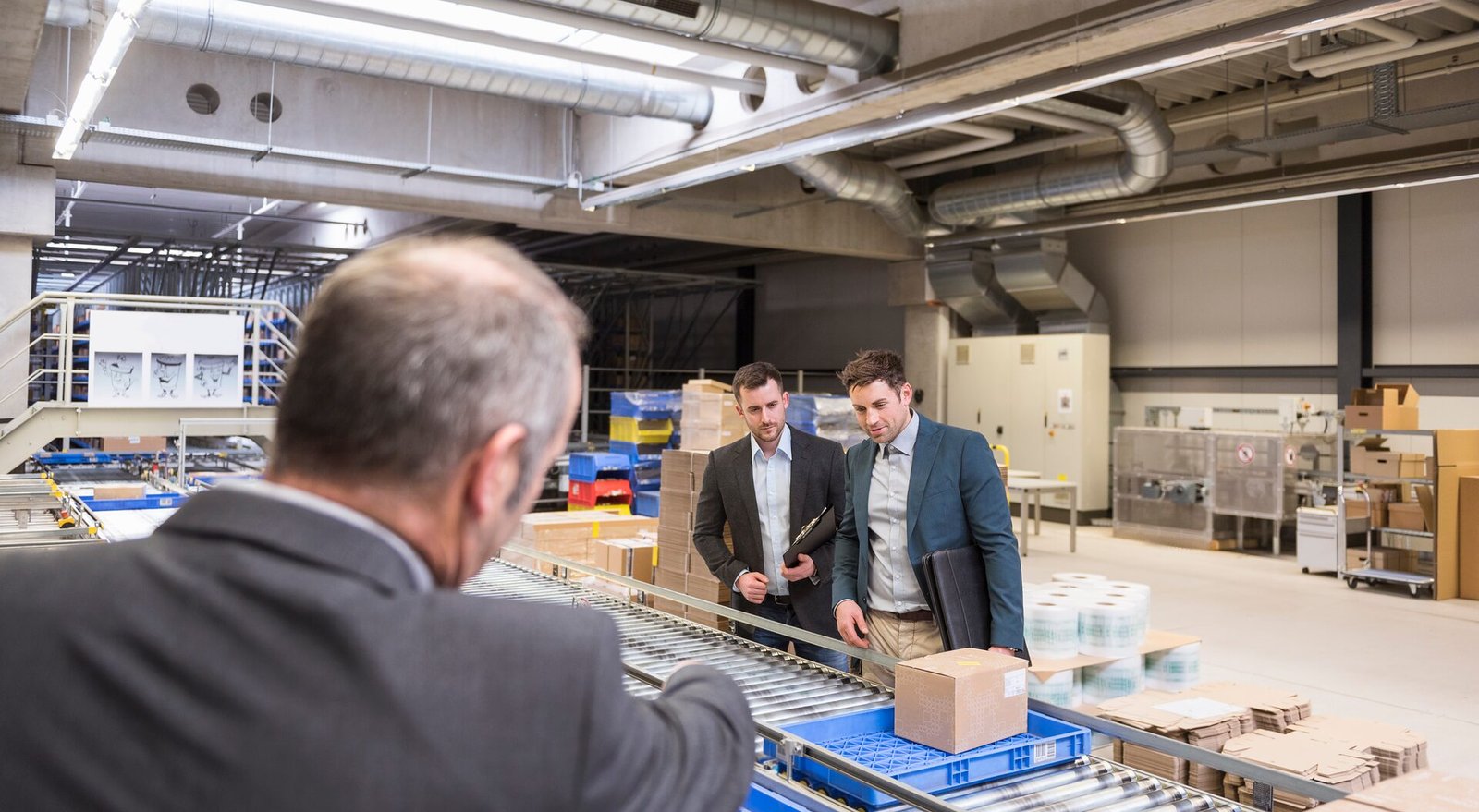 Beratung zur digitalen Transformation: Rundgang der Geschäftsführung am Förderband im Versandlager